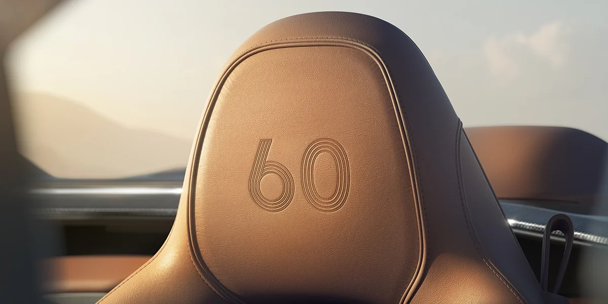 Aston Martin Vanquish Volante 60th Anniversary interior highlighting elegant wood trim, two-tone leather seating, and high-definition touchscreen display.