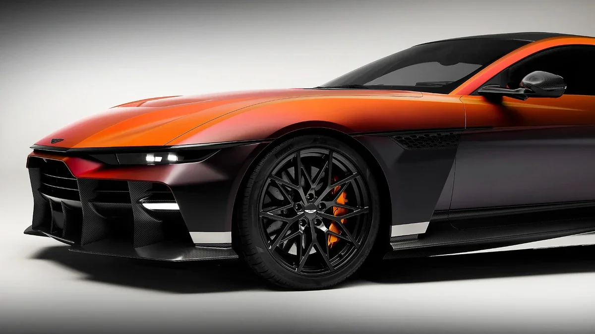 Close view of the Aston Martin Valen front wheel, brake hardware, carbon-fiber aerodynamic surfaces, and sculpted front bodywork.